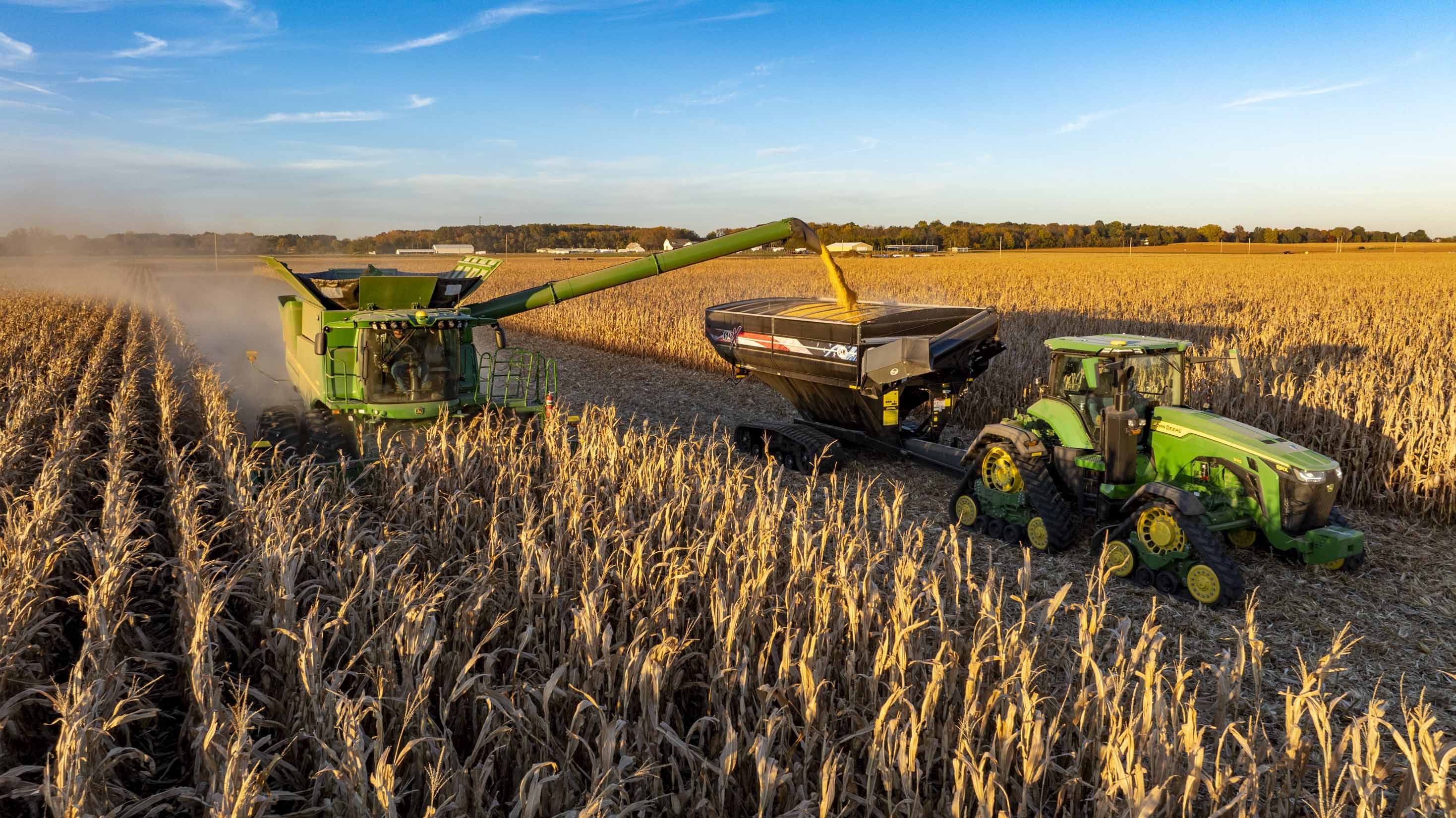 combine and tractor in corn field