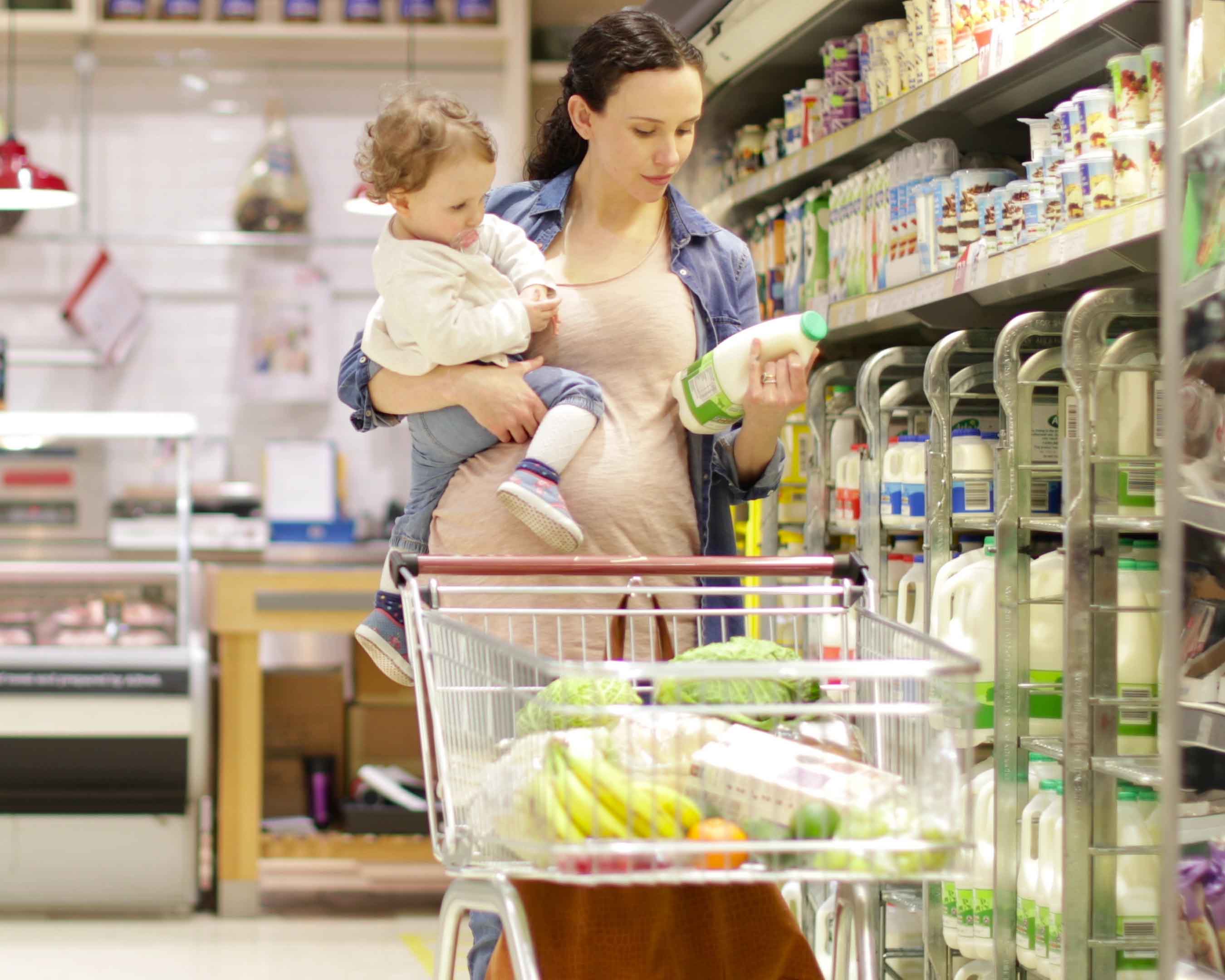 Pregnant mother with daughter grocery shopping